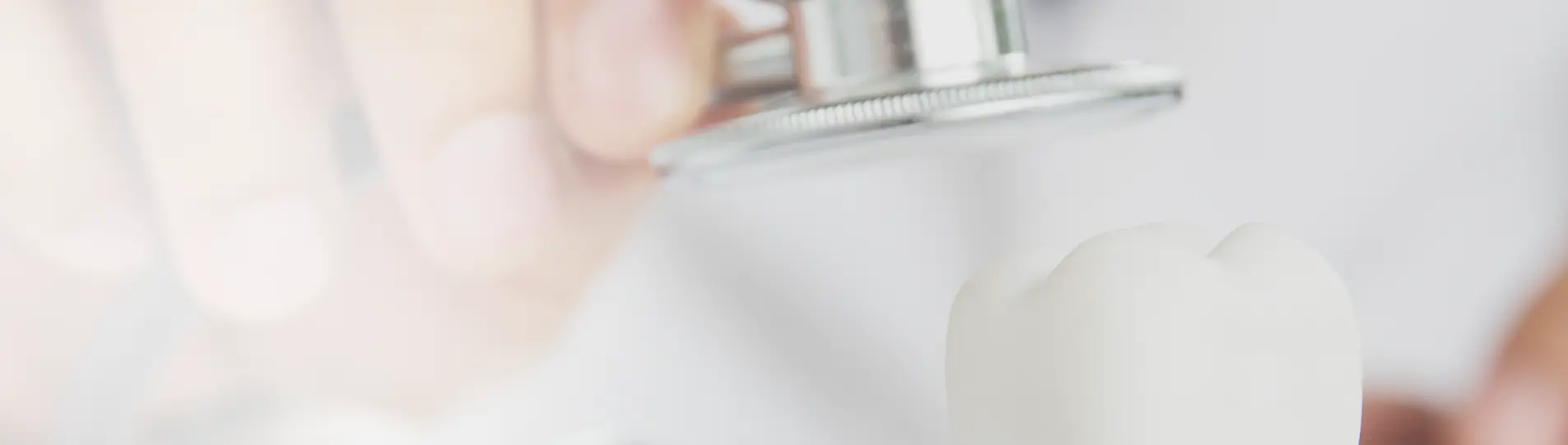 Dentist examining a tooth model with a stethoscope, symbolizing the development and diagnosis of tooth decay.
